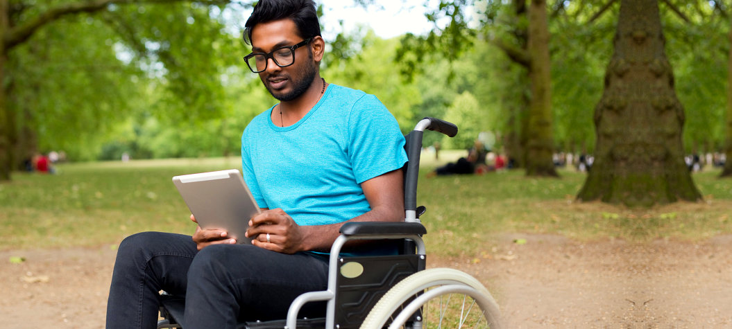 indian man in a wheelchair using a tablet